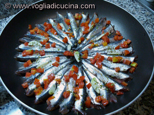 Anchovies (anchovies) in pan with tomatoes and capers